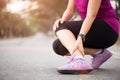 Woman suffering from an ankle injury while exercising. Running sport injury concept