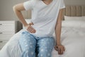 Woman suffering from appendicitis inflammation on bed