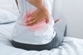 Woman suffering from back pain, sitting on bed Royalty Free Stock Photo