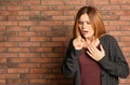 Woman suffering from cough near brick wall. Royalty Free Stock Photo