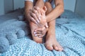 Woman suffering from feet pain or feet ache and massaging painful foot. Leg cramps, pain in legs or muscle spasm Royalty Free Stock Photo