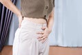 woman suffering from lower back and abdominal pain caused by premenstrual syndrome PMS,