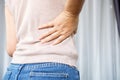 Woman suffering from lower back pain, hand holding right side back pain Royalty Free Stock Photo