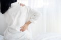 Woman suffering from neck, shoulder and lower back pain sitting in bed wakeup in the morning feeling pain muscles and nerve Royalty Free Stock Photo