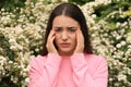 Woman suffering from seasonal pollen allergy near blossoming tree on spring day Royalty Free Stock Photo