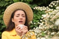 Woman suffering from seasonal pollen allergy near blossoming tree Royalty Free Stock Photo