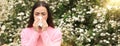 Woman suffering from seasonal pollen allergy near blossoming tree on spring day. Banner design with space for text Royalty Free Stock Photo