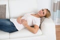 Woman Suffering From Stomach Pain While Lying On Sofa Royalty Free Stock Photo