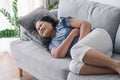 Woman suffering from stomachache lying down on the sofa at home. abdominal pain, Gastritis, Period, menstruation Royalty Free Stock Photo