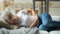 Woman suffering from stomachache lying down on sofa Royalty Free Stock Photo