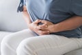 Woman suffering from stomachache sitting on the sofa at home. abdominal pain, Gastritis, Period, menstruation Royalty Free Stock Photo