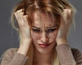 Woman suffering from stress or headache while being offended by pain, Royalty Free Stock Photo