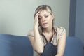 Woman suffering from stress or a headache grimacing in pain as she holds the back of her neck with her other hand to her temple, w Royalty Free Stock Photo