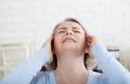 Woman suffering from stress or a headache grimacing in pain as she holds the back of her neck with her other hand to her Royalty Free Stock Photo