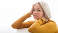 Woman suffering from stress or a headache grimacing in pain as she holds the back of her neck with her other hand to her Royalty Free Stock Photo