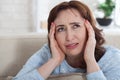 Woman suffering from stress or a headache grimacing in pain as s Royalty Free Stock Photo