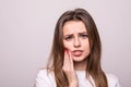 Woman suffering from toothache, tooth decay or sensitivity isolated on gray