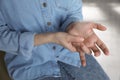 Woman suffering from trigger finger at home, closeup