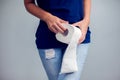 Woman suffers from diarrhea holds toilet paper roll. Stomach ups Royalty Free Stock Photo