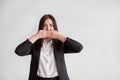 Woman in a suit, blocking her mouth, business compliance concept Royalty Free Stock Photo