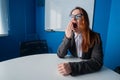 A woman in a suit and glasses makes yawns in the conference room. A female office manager with chronic fatigue sits at a Royalty Free Stock Photo