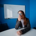 A woman in a suit and glasses makes yawns in the conference room. A female office manager with chronic fatigue sits at a Royalty Free Stock Photo