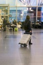 Woman with a suitcase at the airport. Protecting a suitcase from thieves.