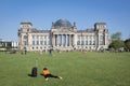 Woman with suitcase laying in front of Reichstag building in Berlin
