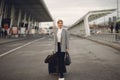 Woman with suitcase standing by the airport Royalty Free Stock Photo