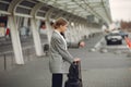 Woman with suitcase standing by the airport Royalty Free Stock Photo
