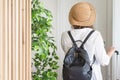 Woman with suitcase and straw hat in shirt and shorts going to the door and waiting a taxi. ready to trip. Individual traveler Royalty Free Stock Photo