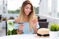Woman summer cafe, hand credit card phone, pays purchase, orders goods, writes off money account. Contactless payment Royalty Free Stock Photo
