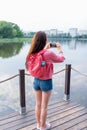 Woman in summer in city near lake, river pond, photographing landscape smartphone, recording video Internet, application Royalty Free Stock Photo