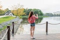 Woman summer in city near lake, river pond, photographing landscape smartphone, recording video to Internet, application Royalty Free Stock Photo