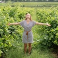 Woman walking in a vineyard, looking to the sky, arms outstretched Royalty Free Stock Photo