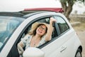 Woman in summer hat driver holding car keys driving her new car cabriolet - automobile and purchase concept Royalty Free Stock Photo