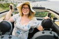 Woman in summer hat driver holding car keys driving her new car cabriolet - automobile and purchase concept Royalty Free Stock Photo