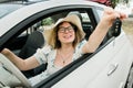 Woman in summer hat driver holding car keys driving her new car cabriolet - automobile and purchase concept Royalty Free Stock Photo