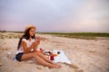 Woman in summer Picnic on the beach at sunset in the white plaid Royalty Free Stock Photo