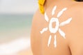 woman with sun-shaped suntan lotion on her shoulder, relaxing on the beach and taking care of her health. happy girl Royalty Free Stock Photo