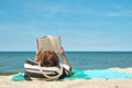 Woman sunbathing on the beach with book Royalty Free Stock Photo