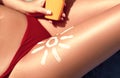 Woman sunbathing on the beach. Close-up view on the legs with lotion sun shape/ Royalty Free Stock Photo