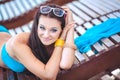 Woman sunbathing in bikini at tropical travel resort. Beautiful young woman lying on sun lounger near pool. Royalty Free Stock Photo