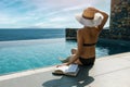 Woman sunbathing and relaxing by the swimming pool with sea view in luxury villa Royalty Free Stock Photo