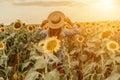 Woman sunflower field. Happy girl in blue dress and straw hat posing in a vast field of sunflowers at sunset. Summer Royalty Free Stock Photo