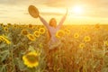 Woman sunflower field. Happy girl in blue dress and straw hat posing in a vast field of sunflowers at sunset. Summer Royalty Free Stock Photo