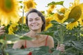 Woman in Sunflower Field: Happy girl in a straw hat posing in a vast field of sunflowers at sunset, enjoy taking picture Royalty Free Stock Photo