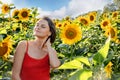 Woman in Sunflower Field: Happy girl in a straw hat posing in a vast field of sunflowers at sunset, enjoy taking picture Royalty Free Stock Photo