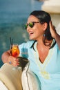 Woman with sunglasses drinking cocktail on a yacht