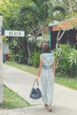 Woman in sunglasses with fashion snakeskin python bag walking on the street. Bali island, Indonesia. Royalty Free Stock Photo